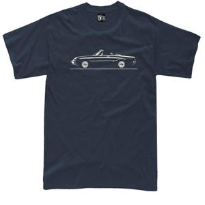 Peut inclure: T-shirt bleu marine avec un dessin blanc d'une voiture décapotable. La voiture est représentée de profil, avec ses roues et son toit ouvert. Le t-shirt a un col rond et des manches courtes.