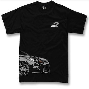 May include: Black t-shirt with a grey and white graphic of a car's front. The text "MK2" is printed in white on the upper right chest. The shirt has short sleeves and a crew neck. A car-themed apparel item.