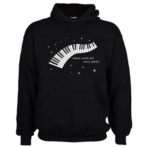 Black hooded sweatshirt with a white graphic of a piano keyboard and the text "Where words fail, music speaks".