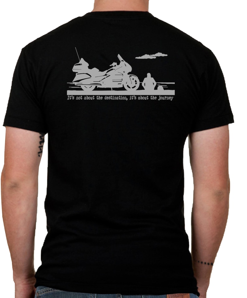 May include: Black t-shirt featuring a motorcycle graphic and the text "It's not about the destination, it's about the journey." The graphic includes a motorcycle, a person, and clouds. The shirt is made of a soft material.