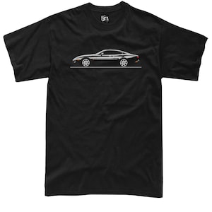 Puede incluir: Camiseta negra con una ilustración de perfil de un coche deportivo negro. El coche tiene detalles blancos y está sobre una línea blanca. La camiseta tiene cuello redondo y mangas cortas.