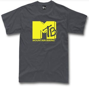 Peut inclure: T-shirt gris foncé avec un grand logo "MTB" jaune et l'inscription "MOUNTAIN BIKING" en dessous. Le t-shirt est de style col rond.