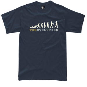 Puede incluir: Camiseta azul marino con un gráfico blanco que representa la evolución humana, terminando con una persona paseando a otra con una correa. El texto "THE EVOLUTION" está impreso debajo.