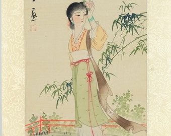 May include: A traditional Japanese painting depicts a woman in a flowing green and white dress, holding a flower. She wears a yellow top and a long brown scarf. Bamboo and text are in the background. The artwork is framed with a cream-colored border.