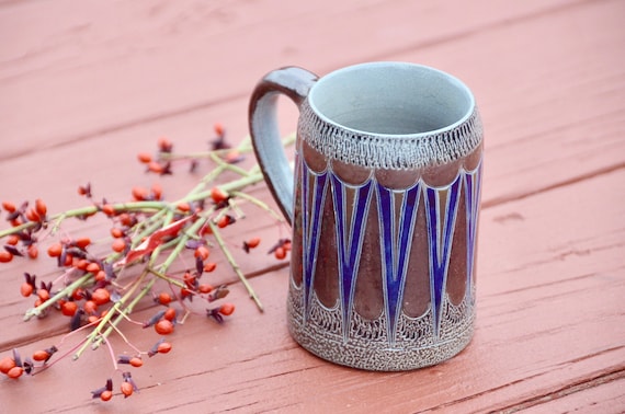 A handmade Danish-style mug with bold blue geometric MCM pattern, signed 'Handarbeit' on the bottom — 29 favorites is a screaming signal that people immediately get it.
