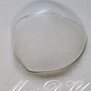 Könnte beinhalten: Eine transparente, kuppelförmige Kunststoffform zum Basteln. Die Form hat eine strukturierte Oberfläche und einen glatten, abgerundeten Rand.