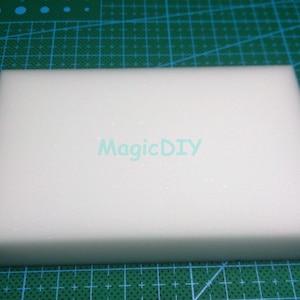 May include: A white rectangular foam block, with the text "MagicDIY" printed on the surface.
