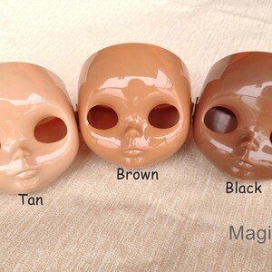 Puede incluir: Tres cabezas de mu&ntilde;eca en diferentes tonos de piel: bronceado, marr&oacute;n y negro. Cada cabeza tiene cuencas de ojos grandes, una nariz peque&ntilde;a y una boca cerrada. La palabra "Brown" est&aacute; escrita debajo de la cabeza del medio, y "Black" debajo de la cabeza derecha. La marca "MagicDIY" est&aacute; en la esquina inferior derecha.