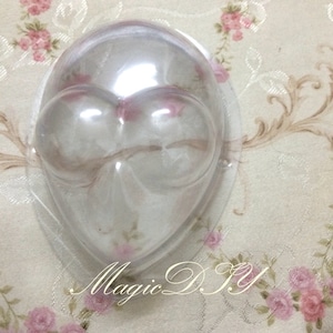 May include: Clear plastic mold shaped like a face with two large round eyes. The mold is designed for making chocolate or other edible treats.