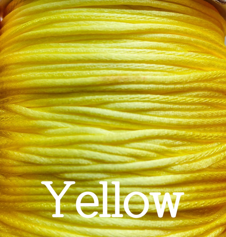 May include: A close-up of a spool of bright yellow thread. The word "Yellow" is printed in white on the spool.