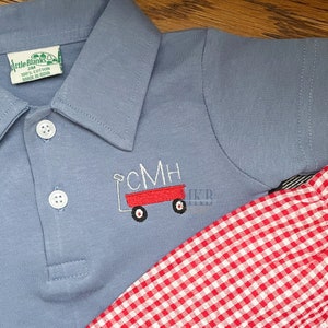 Peut inclure: Un polo bleu clair avec un chariot rouge brod&eacute; sur le devant. Le chariot porte les lettres CMH sur le c&ocirc;t&eacute;. Le polo est associ&eacute; &agrave; un short en vichy rouge et blanc.