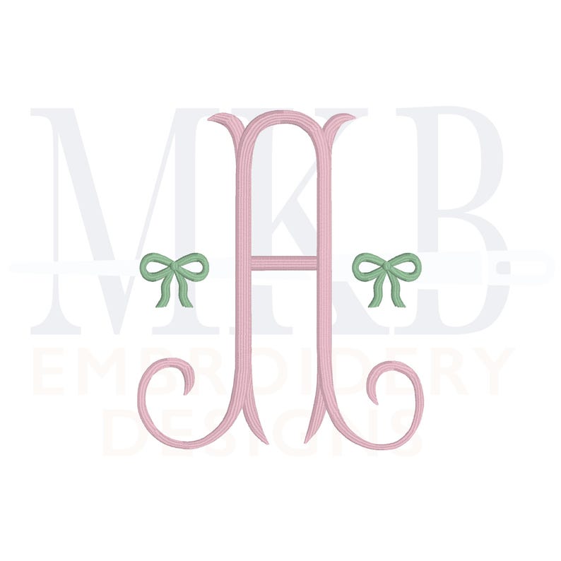 May include: Pink monogram with the letter "A" in the center and the letters "M" and "B" on either side. Green bows are on either side of the "A". The text "Embroidery Designs" is below the monogram.