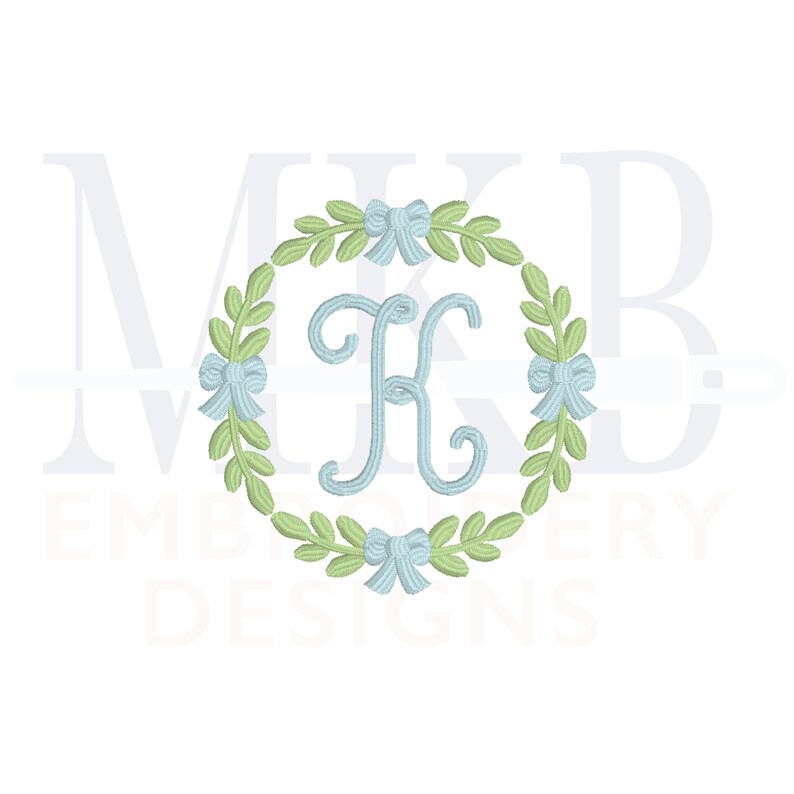 May include: A monogram embroidery design featuring the letter "K" in a light blue colour, surrounded by a wreath of green leaves and blue bows.