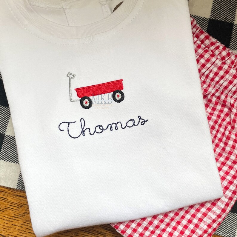 Peut inclure: T-shirt blanc avec broderie de chariot rouge et le nom "Thomas" brod&eacute; en dessous.