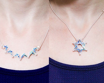 May include: Two silver necklaces with blue and green gemstone pendants. One necklace features a star of David pendant, the other features a series of connected star-shaped pendants.