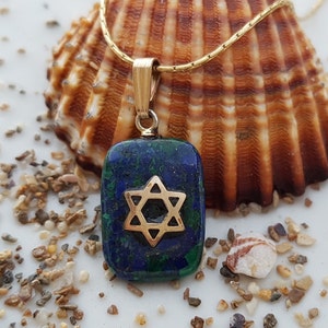 May include: A gold chain necklace with a pendant featuring a blue and green stone with a gold Star of David design.