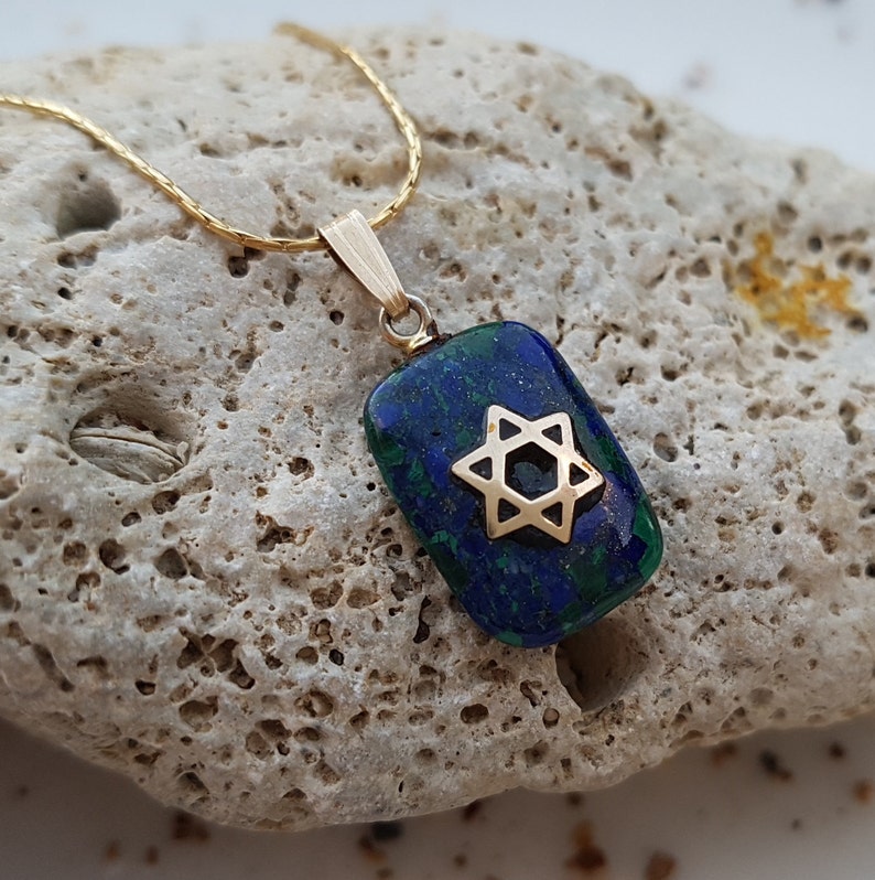 May include: A gold chain necklace with a pendant featuring a blue and green malachite stone with a gold Star of David.