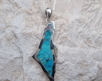May include: A silver chain necklace with a pendant shaped like the outline of Israel. The pendant is filled with turquoise blue stones.