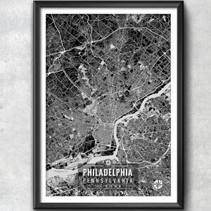 May include: Black and white framed map print of Philadelphia, Pennsylvania. The map shows the city's layout with roads and waterways. The city name and state are printed at the bottom, along with coordinates and a compass rose.