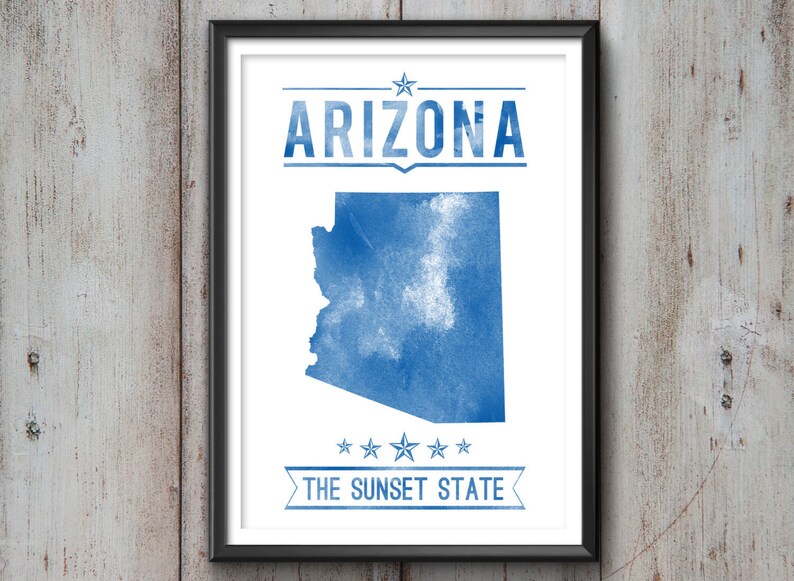May include: Framed print featuring a blue watercolor map of Arizona on a white background. The word "ARIZONA" is above the map, and "THE SUNSET STATE" is below. The print is in a black frame.