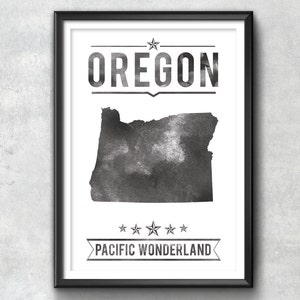 May include: Black and white framed print featuring the state of Oregon. The word "OREGON" is displayed above the state outline, with "PACIFIC WONDERLAND" below. The artwork has a watercolor effect.