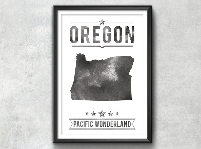 May include: Black and white framed print featuring the state of Oregon. The word "OREGON" is displayed above the state outline, with "PACIFIC WONDERLAND" below. The artwork has a watercolor effect.