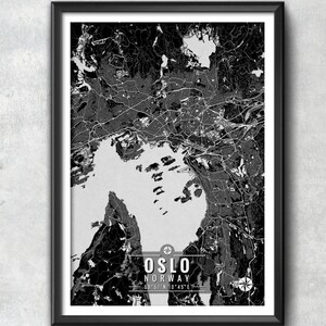 May include: Black and white framed map print of Oslo, Norway. The map shows the city's layout, including roads, waterways, and surrounding areas. The city name and coordinates are displayed at the bottom.