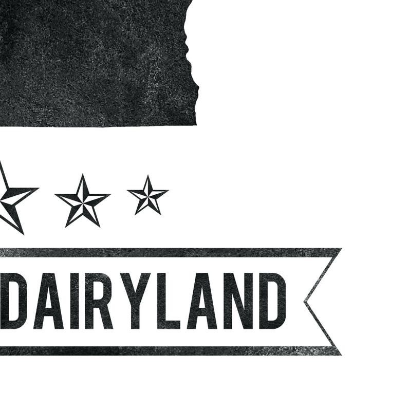 May include: A black and white graphic design featuring the word "DAIRYLAND" in a rectangular banner with a textured appearance. Above the banner are three stars and a silhouette of a state.