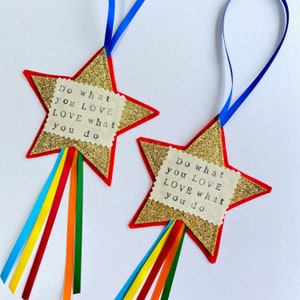 May include: Two star-shaped ornaments with gold glitter, red borders, and blue ribbon hangers. Each has a fabric square with the text "Do what you LOVE LOVE what you do" and rainbow ribbons.