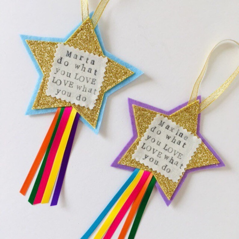 May include: Two star-shaped ornaments with gold glitter centers and colorful ribbon tails. One is blue and the other is purple. Each has a white label with the text "do what you LOVE LOVE what you do".