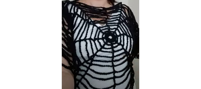 Puede incluir: Top de crochet negro con un dise&ntilde;o de telara&ntilde;a. El top est&aacute; hecho de una tela ligera y aireada y tiene un ajuste holgado y fluido.