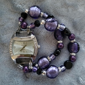 Women&#39;s attractive purple stretch interchangeable watch bracelet with silver watch face with accents on both sides.