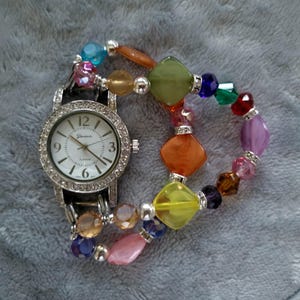 Women’s unique interchangeable stretch watch with multicolored beads and a round white watch face.