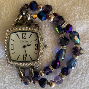Women’s lovely iridescent interchangeable beaded bracelet watch with square silver watch face surrounded with rhinestones.