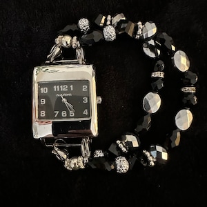 Women&#39;s unique interchangeable black and silver/gray stretch bracelet watch with black watch face.