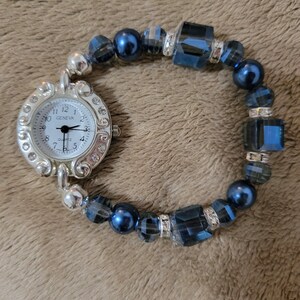 This single watch band is cobalt blue and has different size crystals and pearls with a small watch face.