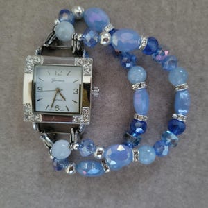 Women&#39;s beautiful blue stretch interchangeable watch bracelet with a square white face with rhinestones in the corners