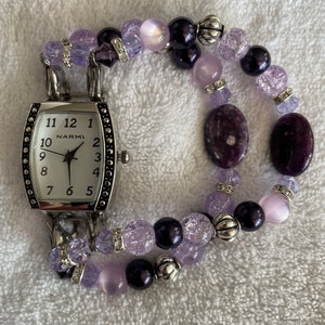 women's vibrant purple stretch interchangeable beaded watch band with white watch face.