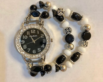 Women’s classy black and white stretch watch bracelet with black watch face.