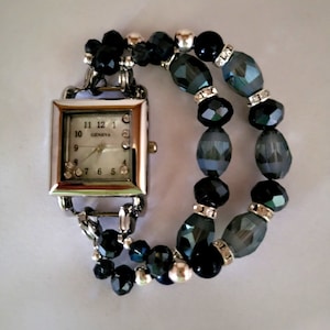Woman&#39;s classic iridescent navy watch bracelet with floating rhinestones in a square face.
