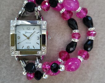 Women’s lively fuchsia and black stretch watch bracelet with a white square watch face.
