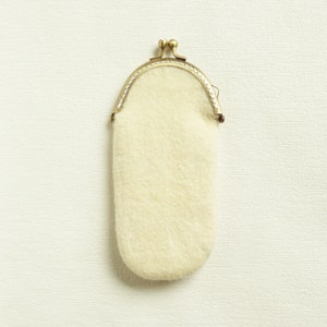 May include: A small, white, fluffy coin purse with a gold metal frame.