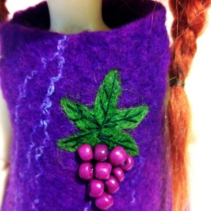 May include: A purple felt doll dress with a green felt leaf and purple felt grapes sewn on the front.
