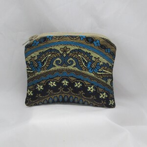 May include: A small, zippered pouch with a black background and a colorful paisley design in shades of blue, gold, and white.