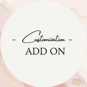 May include: White circle with black text that says "Customization - ADD ON". The text is in a handwritten font. The background is a light pink color.