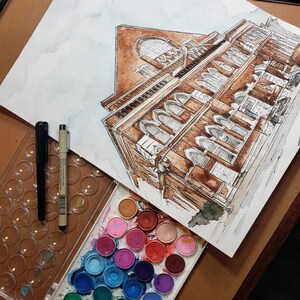 Puede incluir: Una pintura de acuarela de un edificio con una fachada de ladrillo marr&oacute;n y muchas ventanas. La pintura est&aacute; en una hoja de papel blanco y est&aacute; rodeada de una variedad de pinturas de acuarela.