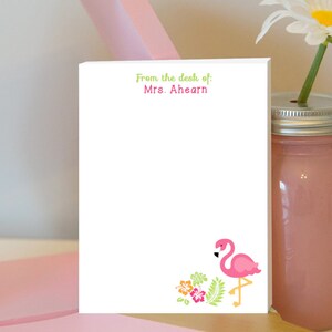 May include: White notepad with the text "From the desk of: Mrs. Ahearn" at the top. The bottom of the notepad features a pink flamingo with green leaves and pink and orange flowers.