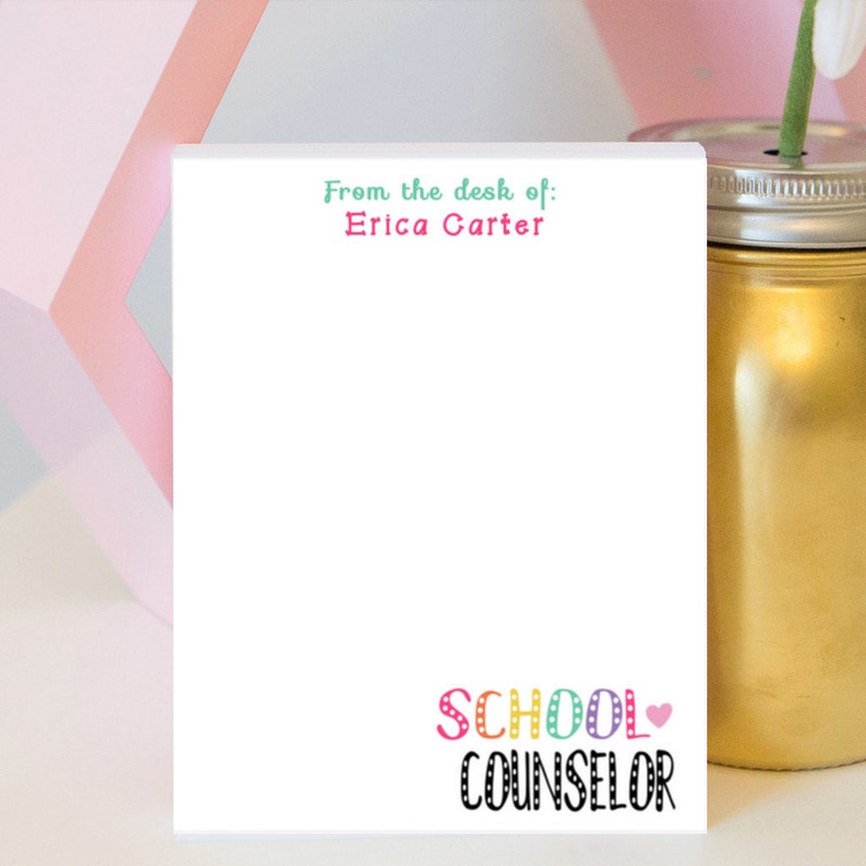 May include: White notepad with the text "From the desk of: Erica Carter" at the top and "SCHOOL COUNSELOR" at the bottom. The text "SCHOOL COUNSELOR" is in colorful letters with polka dots.