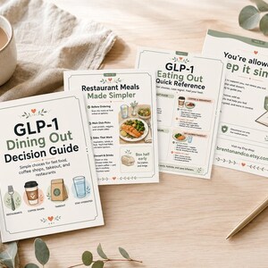 Puede incluir: Una colecci&oacute;n de gu&iacute;as impresas y materiales de referencia sobre una superficie de madera. Las gu&iacute;as incluyen t&iacute;tulos como "GLP-1 Dining Out Decision Guide" y "Restaurant Meals Made Simpler". Tambi&eacute;n hay una taza de caf&eacute; y un bol&iacute;grafo.