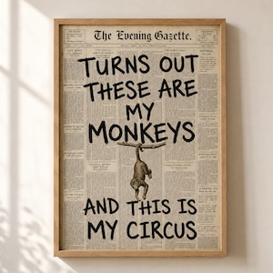 Könnte beinhalten: Ein gerahmter Druck mit einem Hintergrund aus einer alten Zeitung. Fettgedruckter schwarzer Text lautet: "TURNS OUT THESE ARE MY MONKEYS AND THIS IS MY CIRCUS." Eine kleine Illustration eines Affen, der an einem Ast hängt, ist unter dem Text zentriert.